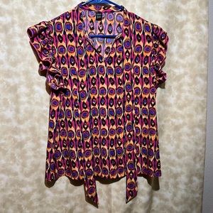 All over print , ruffle trim tee. With flowing tie attached  at the neck.